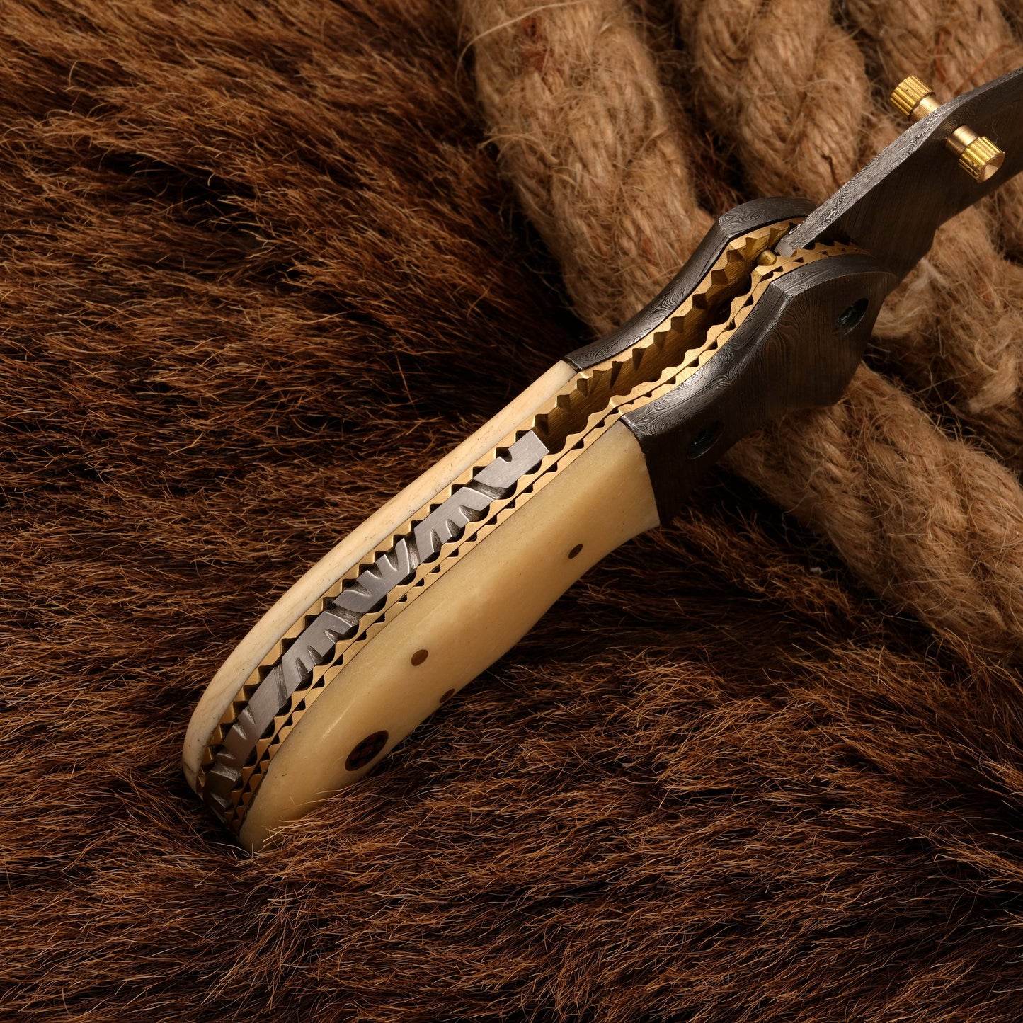 Detailed spine view of a Damascus folding knife with a bone handle, showcasing its intricate craftsmanship and sturdy design.