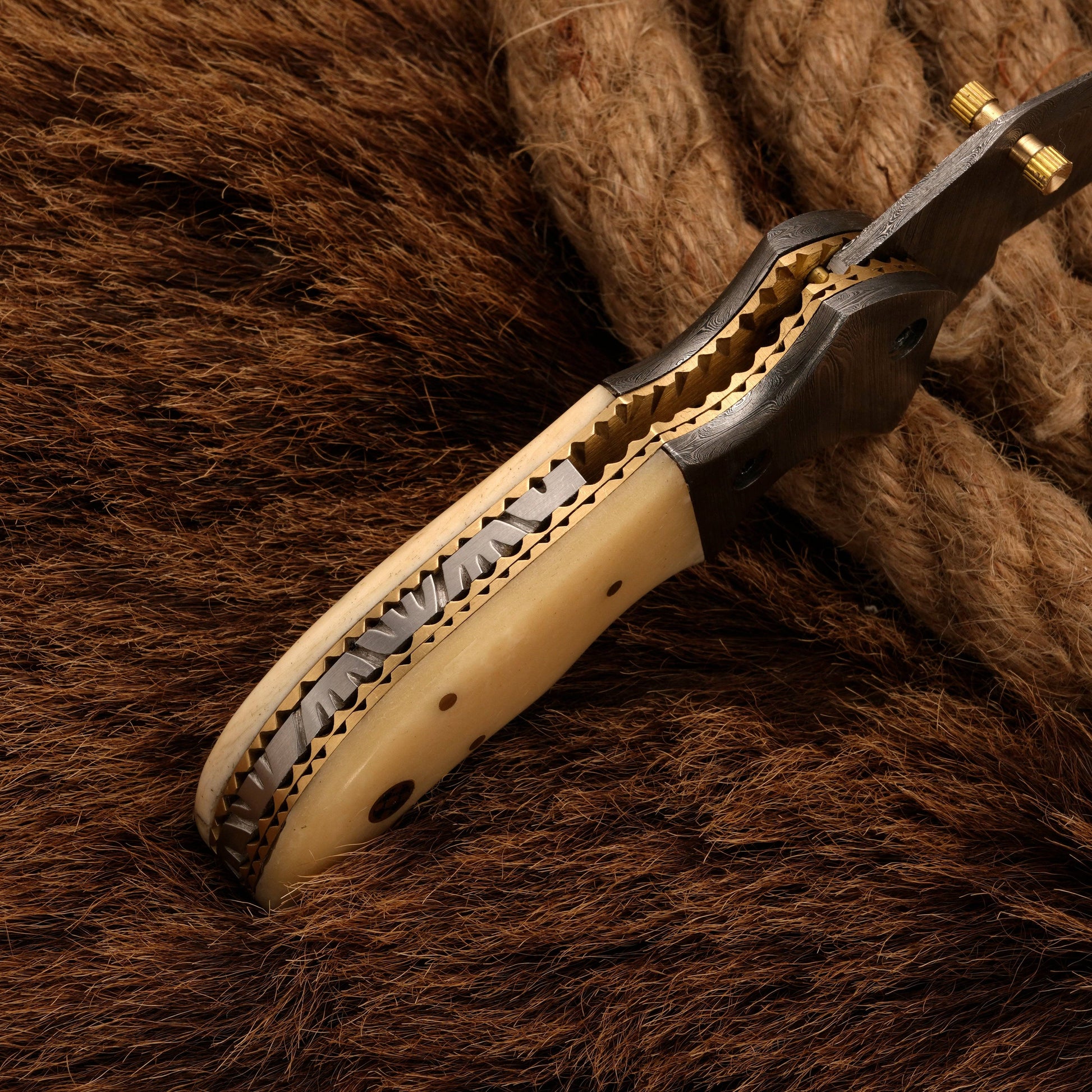 Detailed spine view of a Damascus folding knife with a bone handle, showcasing its intricate craftsmanship and sturdy design.