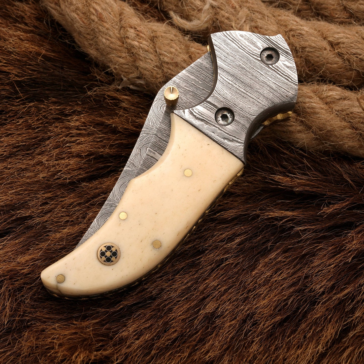 Compact folded view of a Damascus pocket knife with a bone handle, highlighting its portability and elegant design.